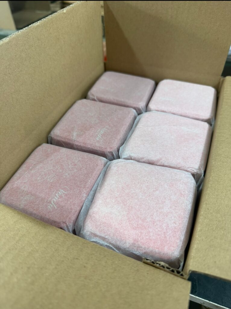 Square tin boxes wrapped with protective material for shipping
